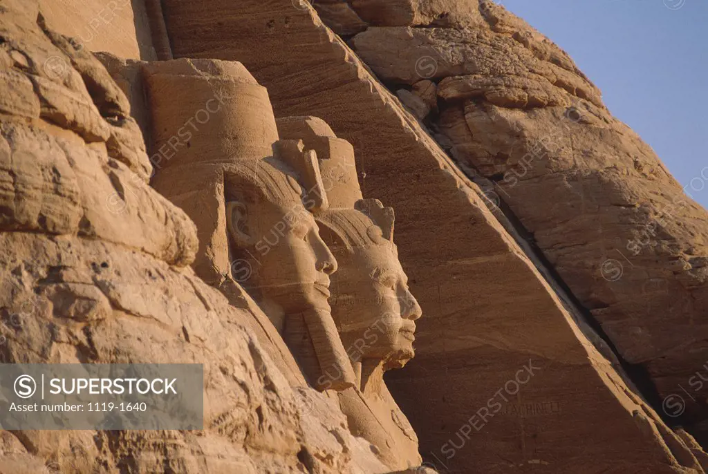Low angle view of statues carved on a rock, Great Temple of Ramses II, Abu Simbel, Egypt