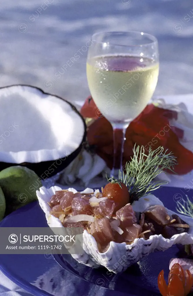 High angle view of meat on a seashell served with a glass of wine