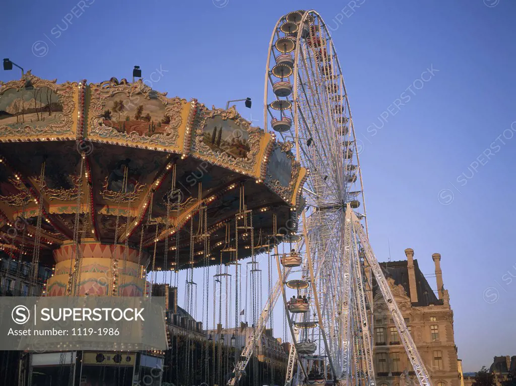 Low angle view of a carousel and a Ferris wheel in an amusement park, Tuileries Park, Paris, France