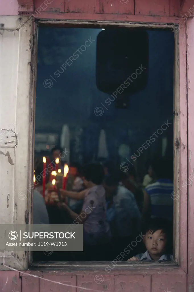 Boy looking through a window, Foshan, China