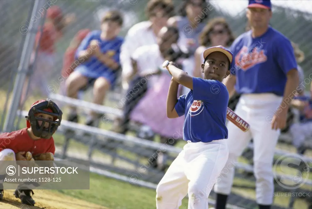 Boy swinging a baseball bat on a field