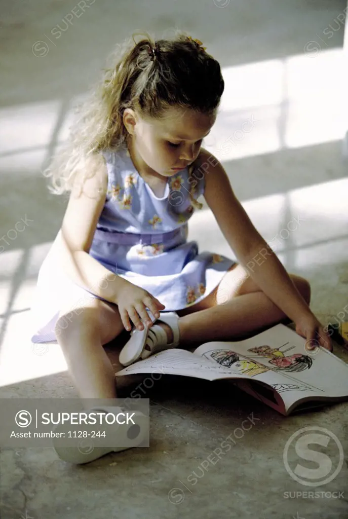 Girl sitting on the floor reading a book