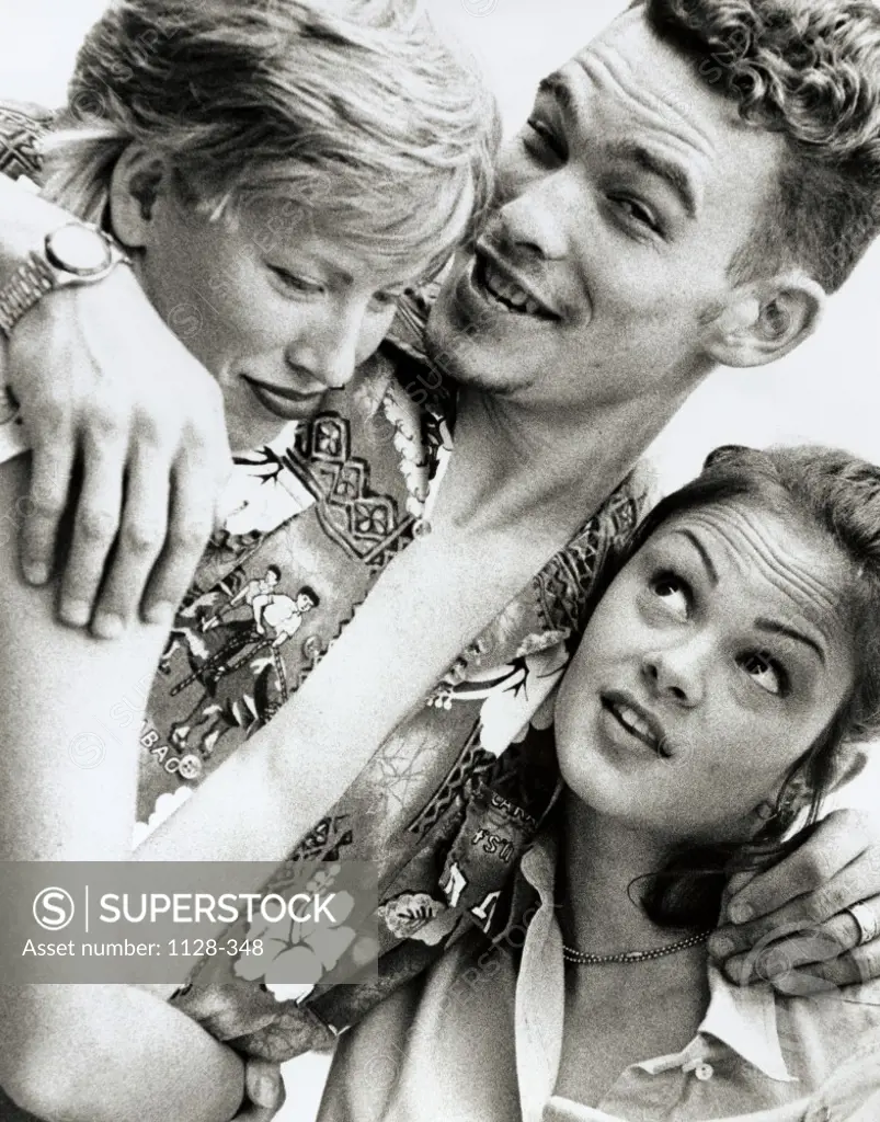 Close-up of a young man embracing two young women