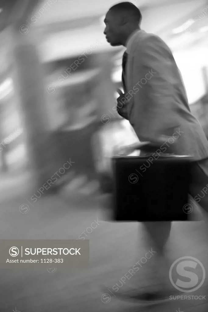 Side profile of a businessman walking with a briefcase