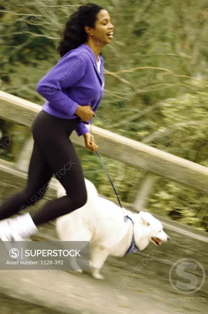 Mid adult woman jogging with her dog