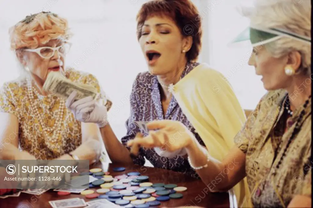 Three senior women playing cards