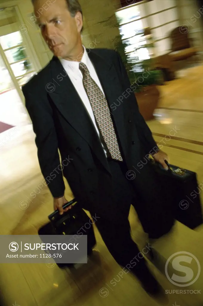 Businessman walking with luggage in a hotel