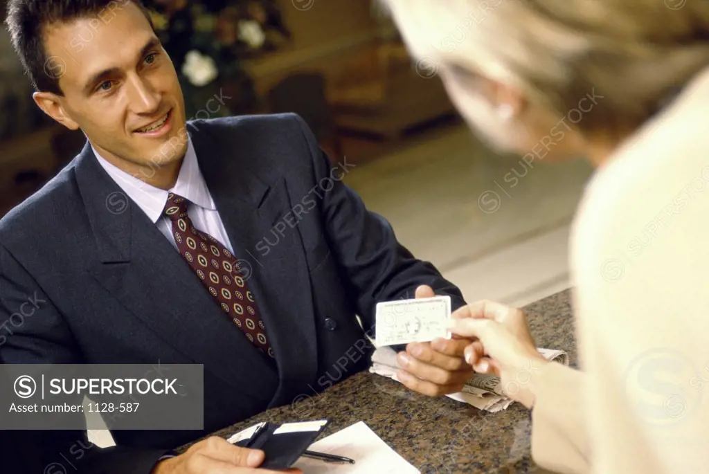 Hotel clerk handing a credit card to a businessman