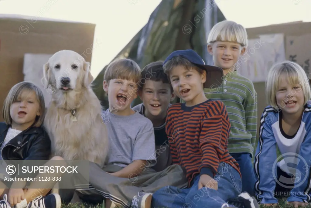 Portrait of a group of children posing with a dog