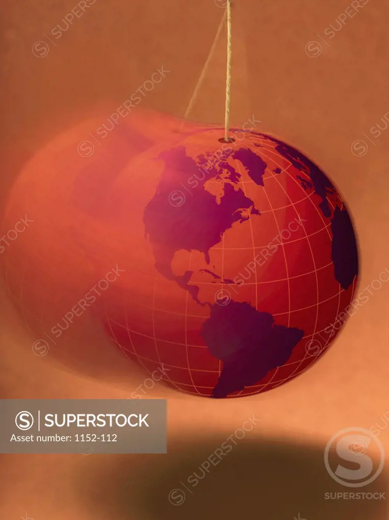 Close-up of a globe swinging on a string
