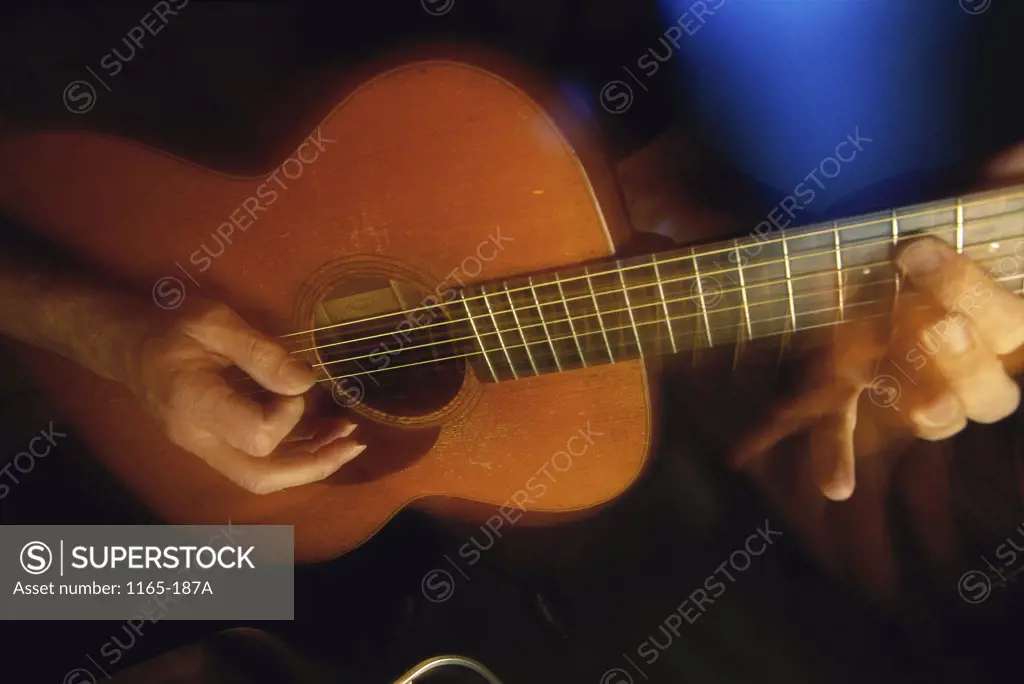 Close-up of a person's hands playing the guitar