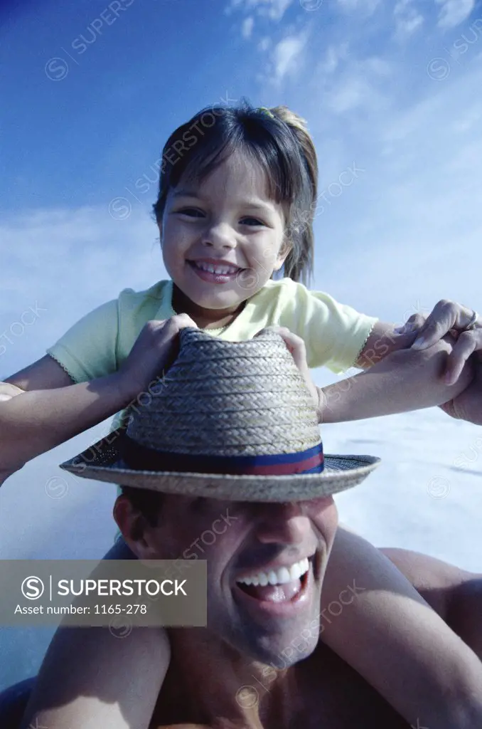 Portrait of a girl sitting on her father's shoulders