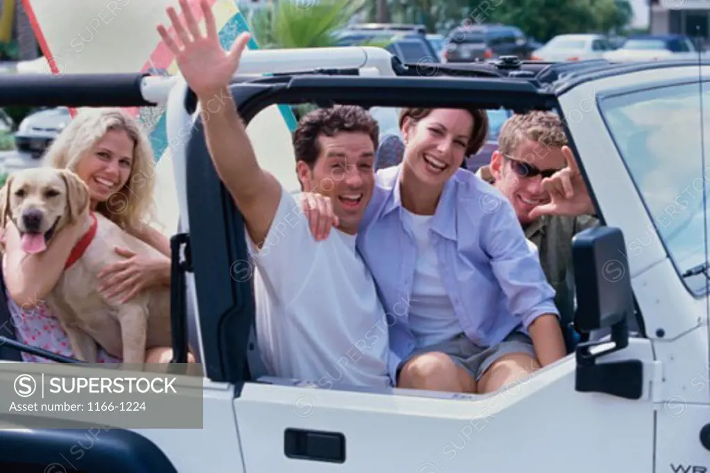 Group of young people sitting in a car smiling