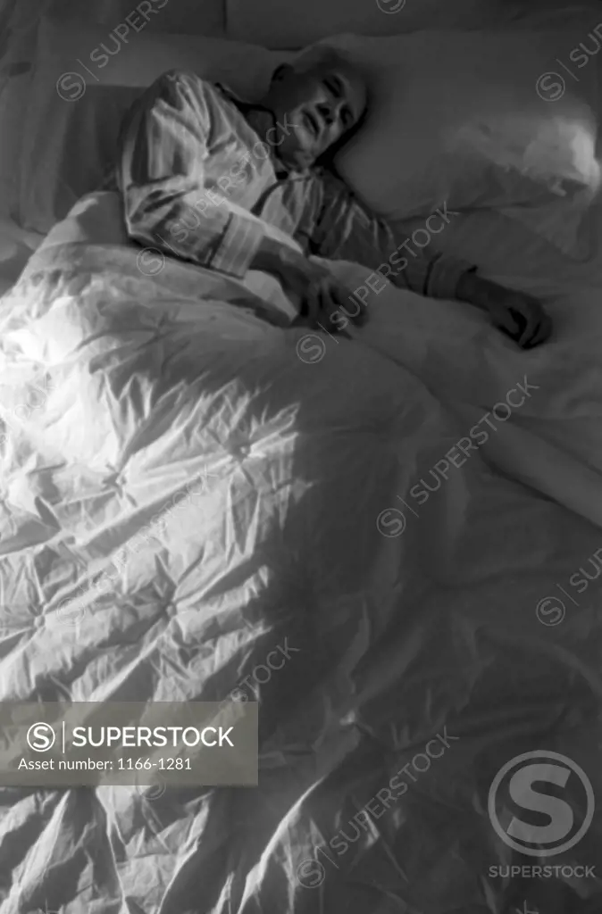 High angle view of a senior man sleeping in a bed