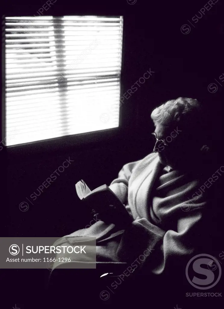 High angle view of a senior woman reading a book