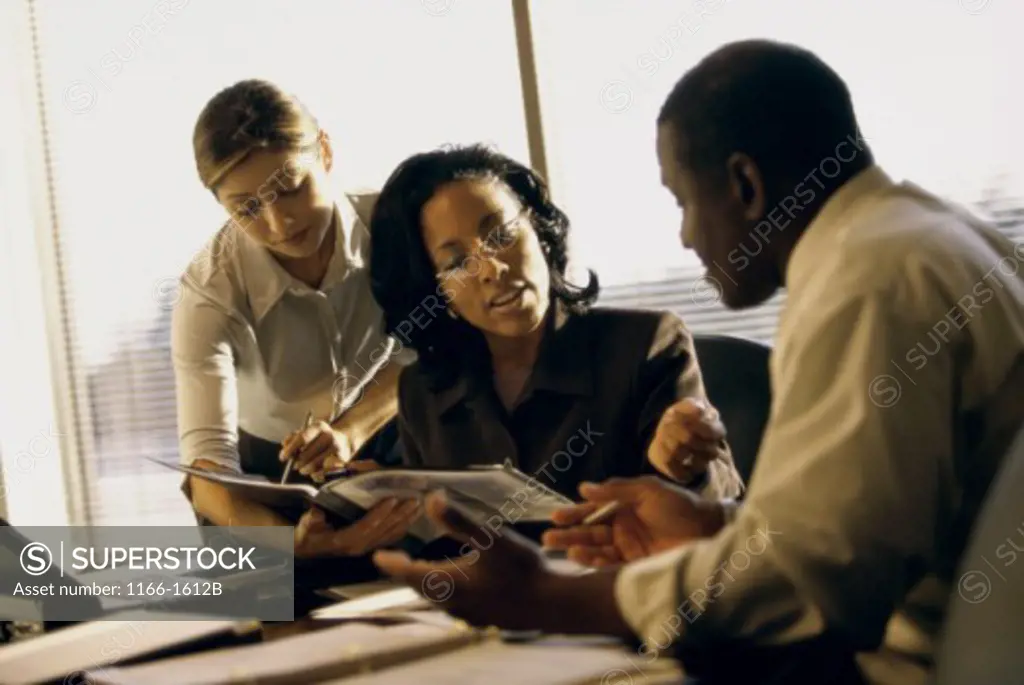 Two businesswomen and a businessman in an office
