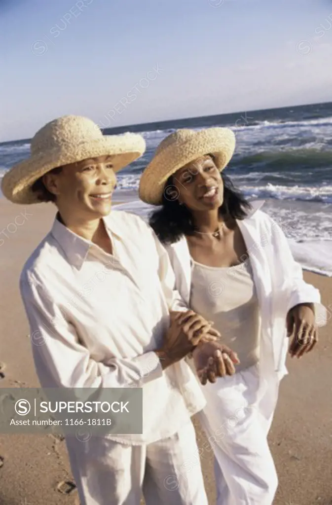 Mature woman walking on the beach with her daughter