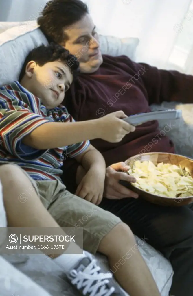 Father watching television with his son