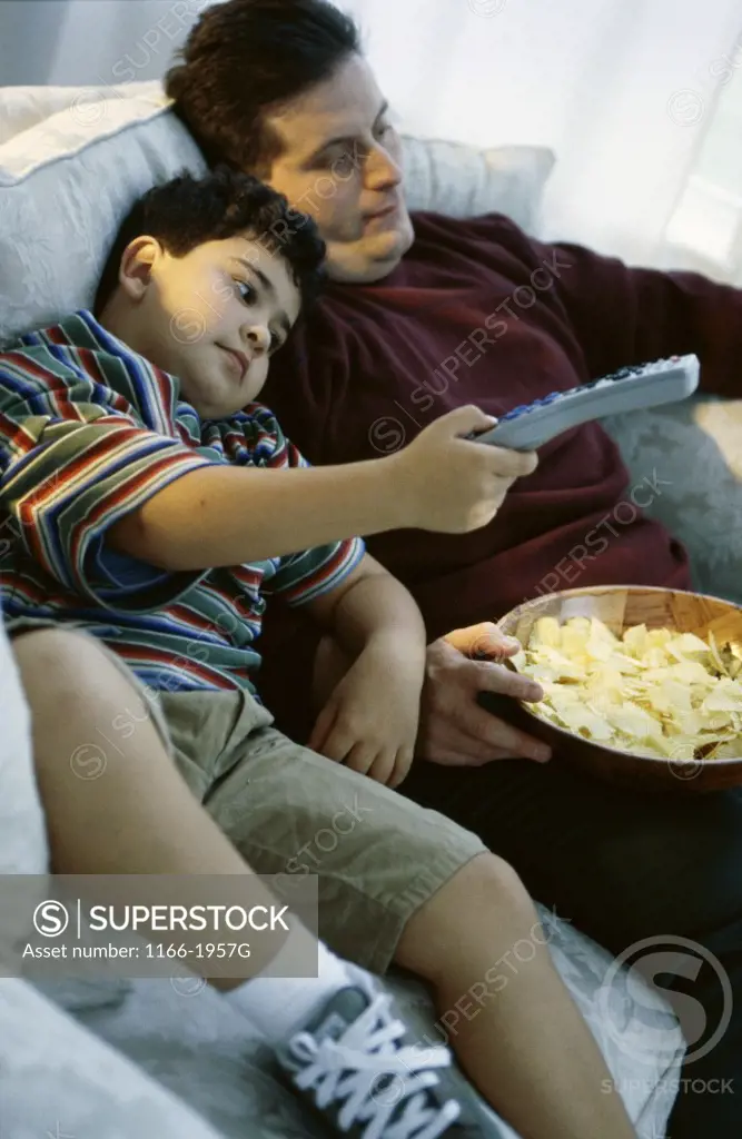 High angle view of a father watching television with his son