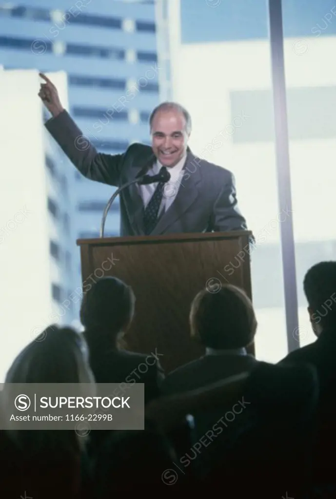 Portrait of a businessman giving a speech at a podium