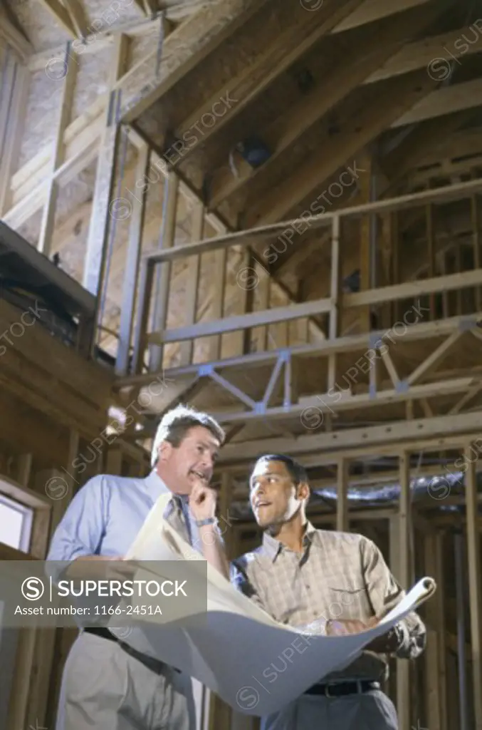 Building contractor holding blueprints