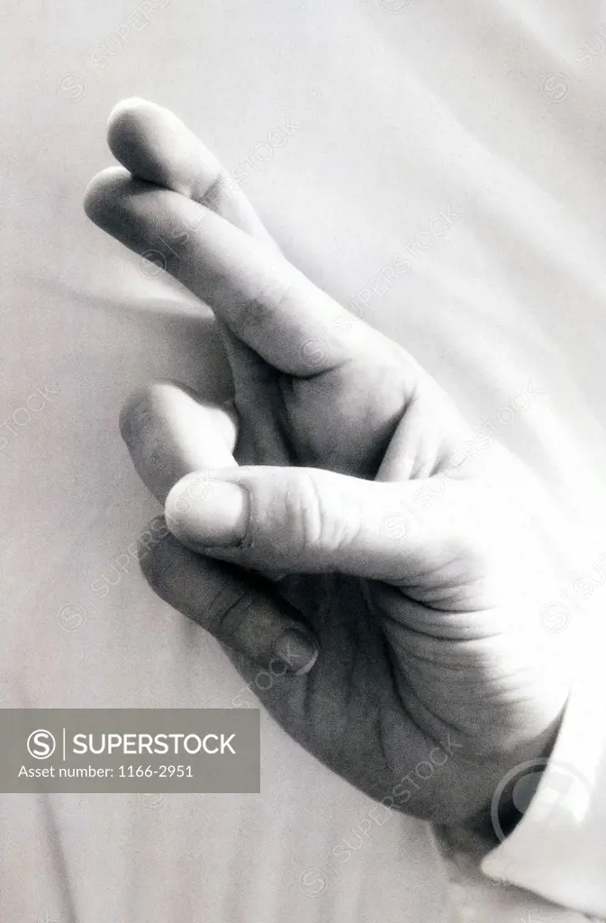 Close-up of a person's fingers crossed