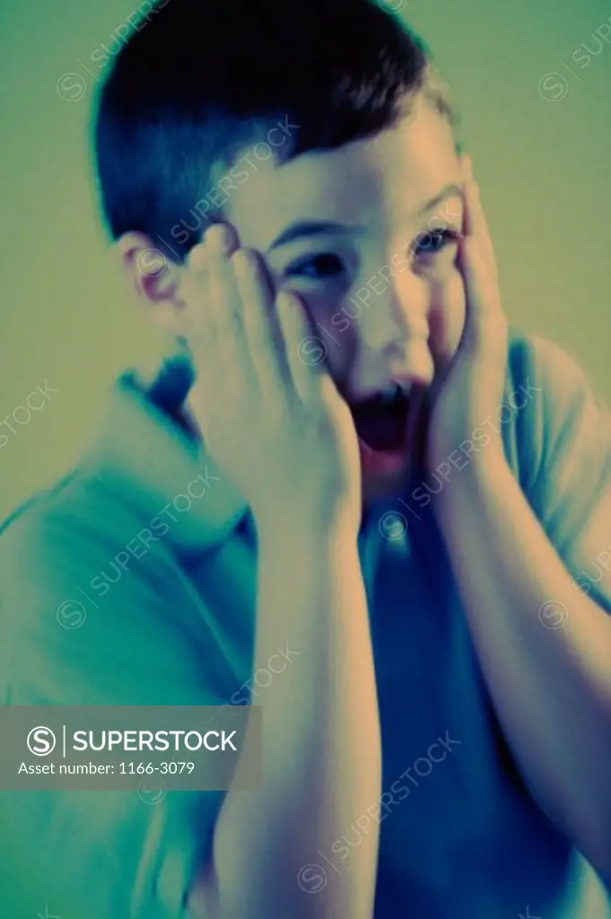 Close-up of a boy shouting in surprise