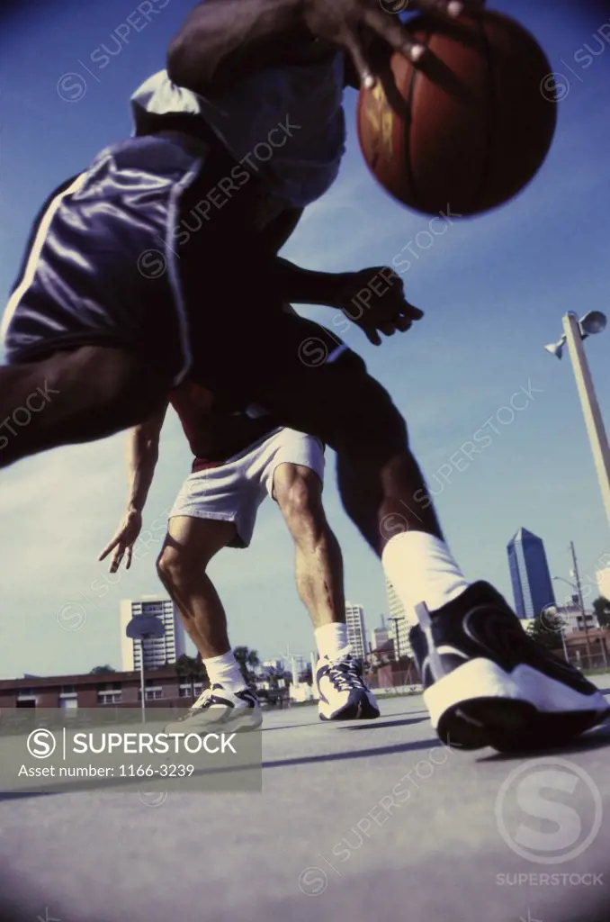 Low angle view of two men playing basketball