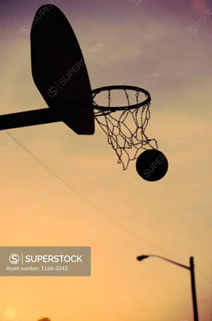 Silhouette of a basketball going through a basketball net