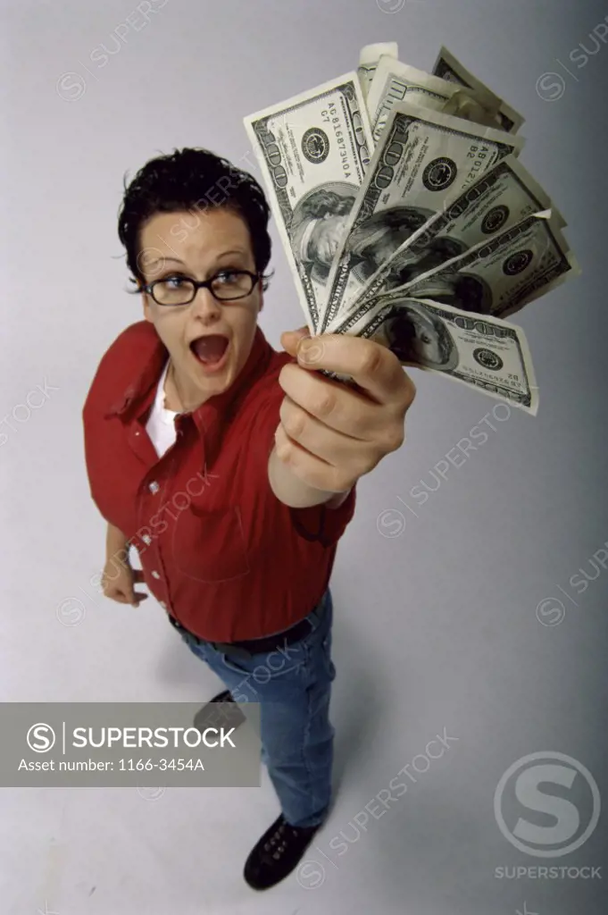 High angle view of a young man standing and holding American banknotes
