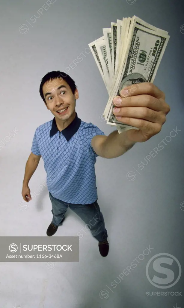 High angle view of a young man holding American banknotes