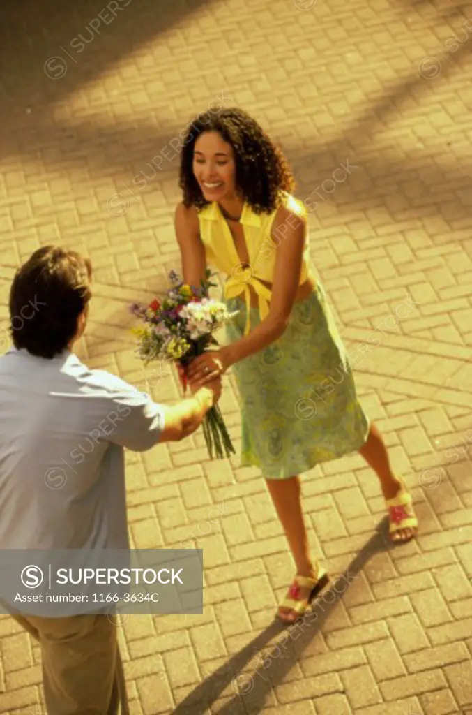 Young man giving a young woman a bouquet of flowers