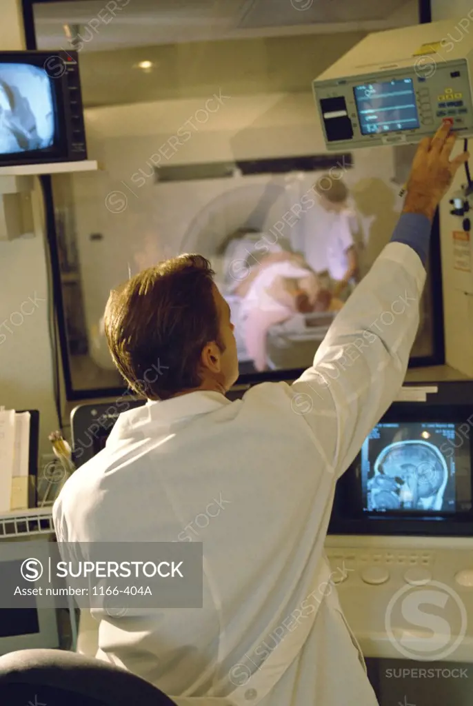 Rear view of a male doctor using a MRI machine