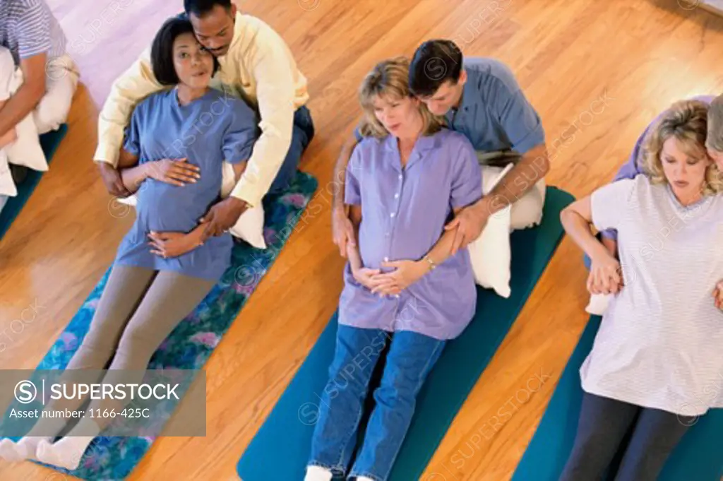 High angle view of husbands and their pregnant wives at a prenatal class