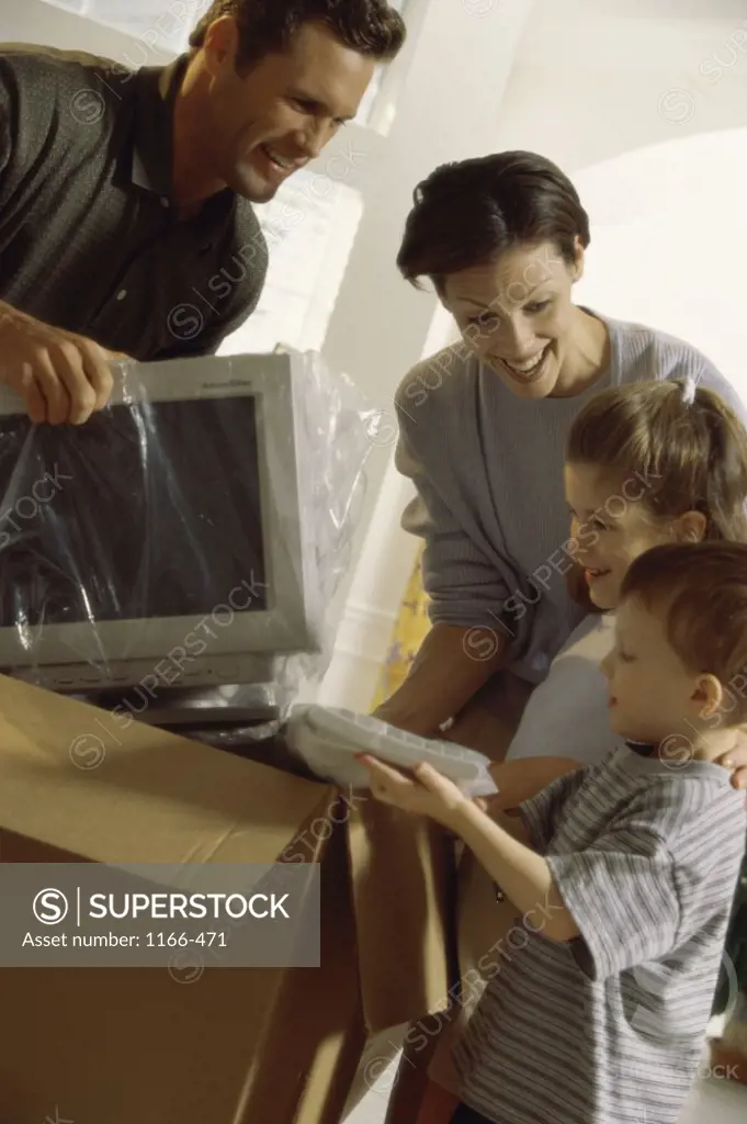 Family unpacking a computer monitor