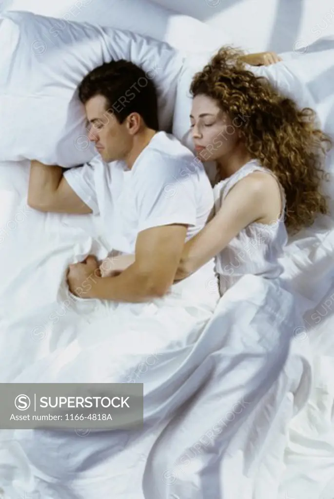 Mid adult couple sleeping on a bed