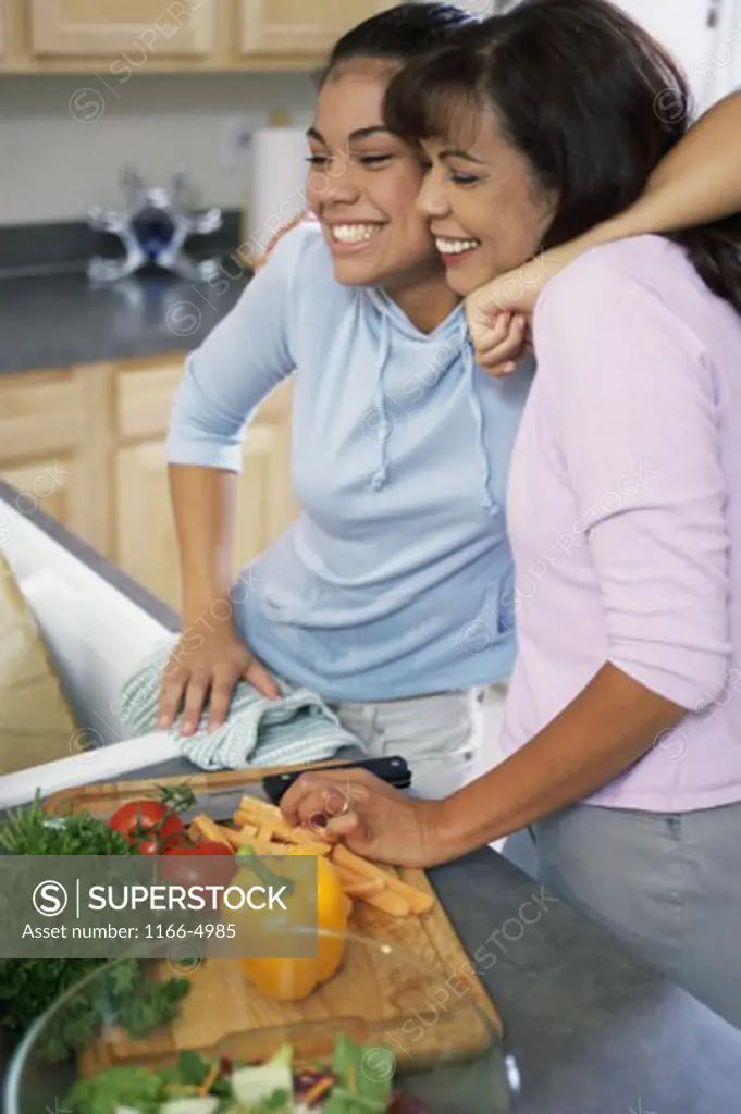 Teenage girl with her mother cooking in a kitchen