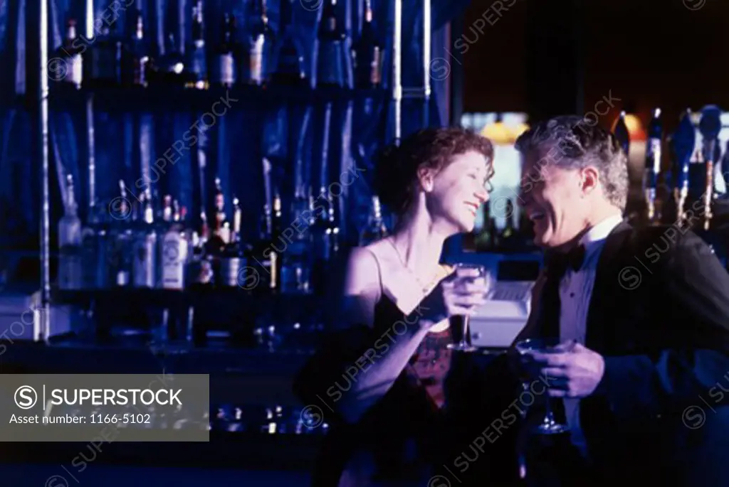 Mid adult couple talking at a bar counter