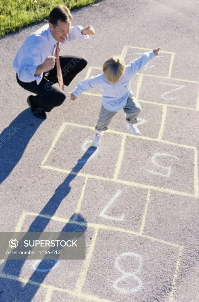 High angle view of a father and his son playing hopscotch
