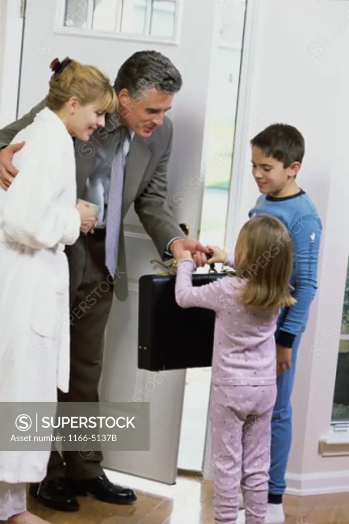 Son and daughter greeting their father at the front door