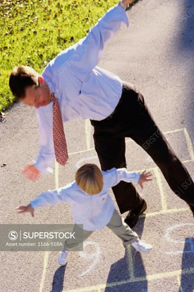 Man playing Hopscotch with his son