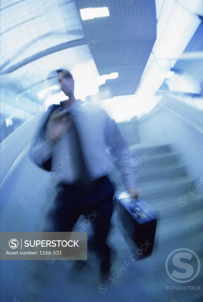 Businessman walking down a staircase with a briefcase
