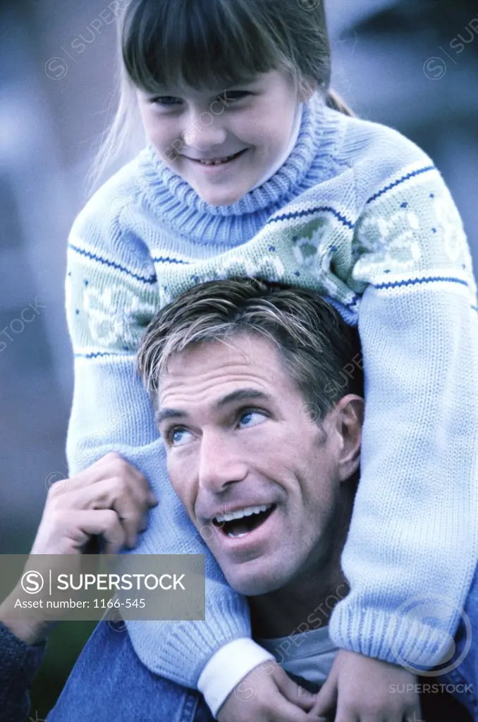 Daughter sitting on her father's shoulders