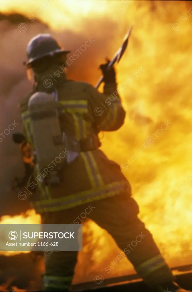 Rear view of a firefighter holding an axe