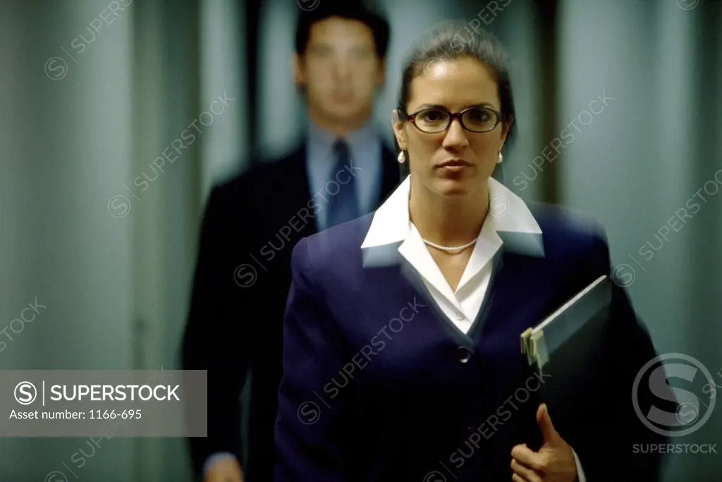 Portrait of a businesswoman and a businessman behind her