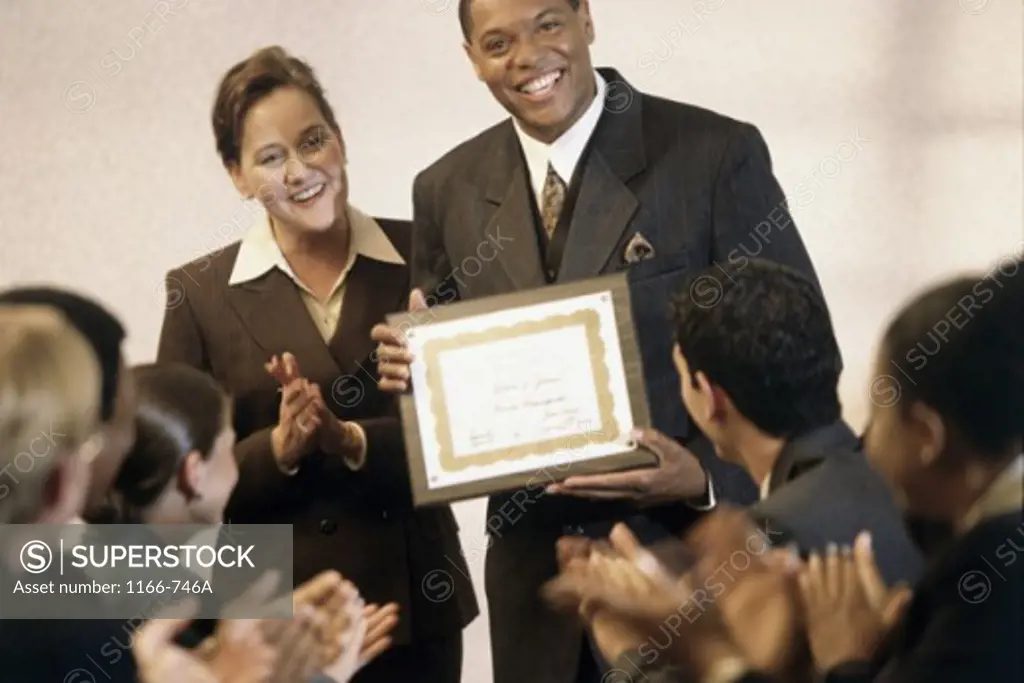 Businessman holding up an award