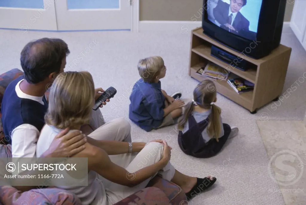 High angle view of parents watching television with their son and daughter