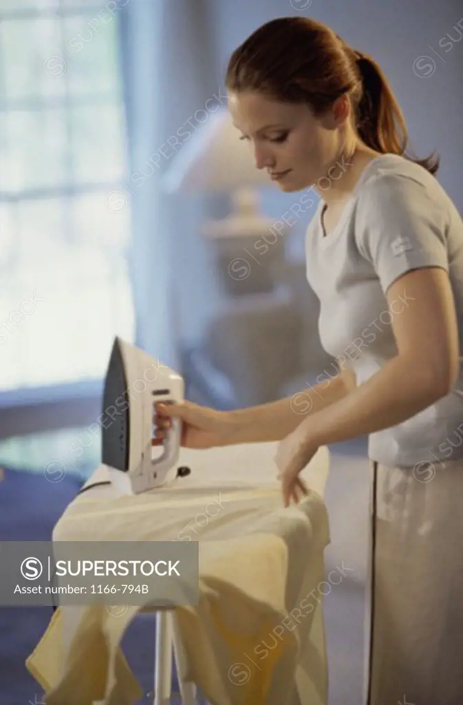 Young woman ironing a shirt