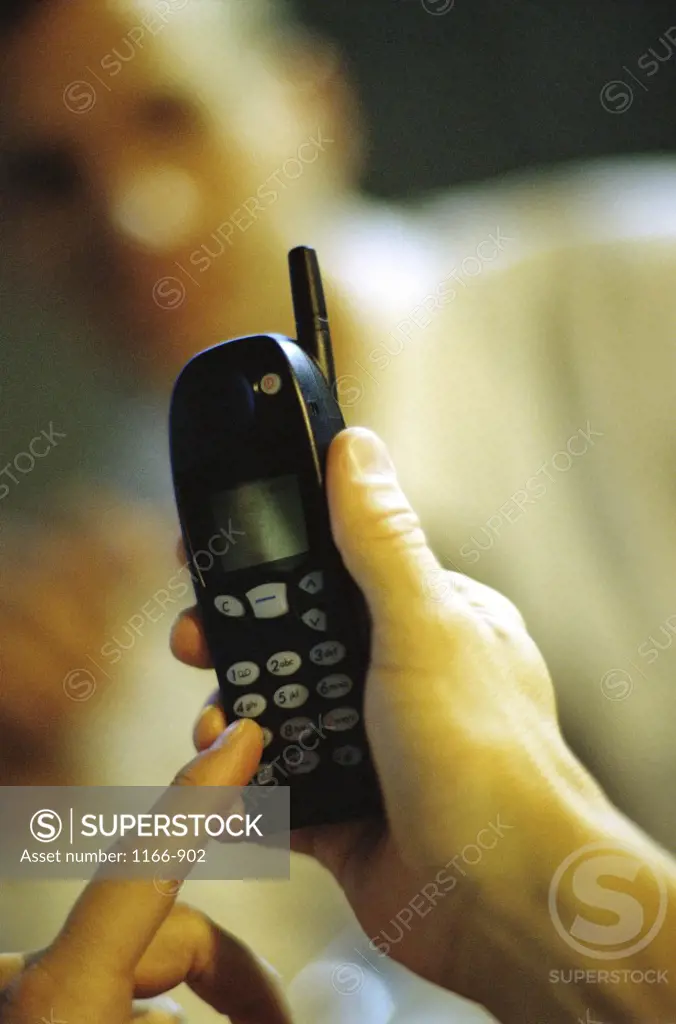 Close-up of a person's hand dialing a mobile phone