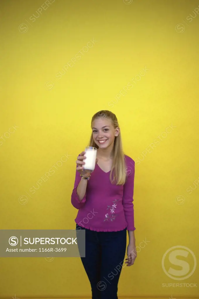 Portrait of a teenage girl holding a glass of milk